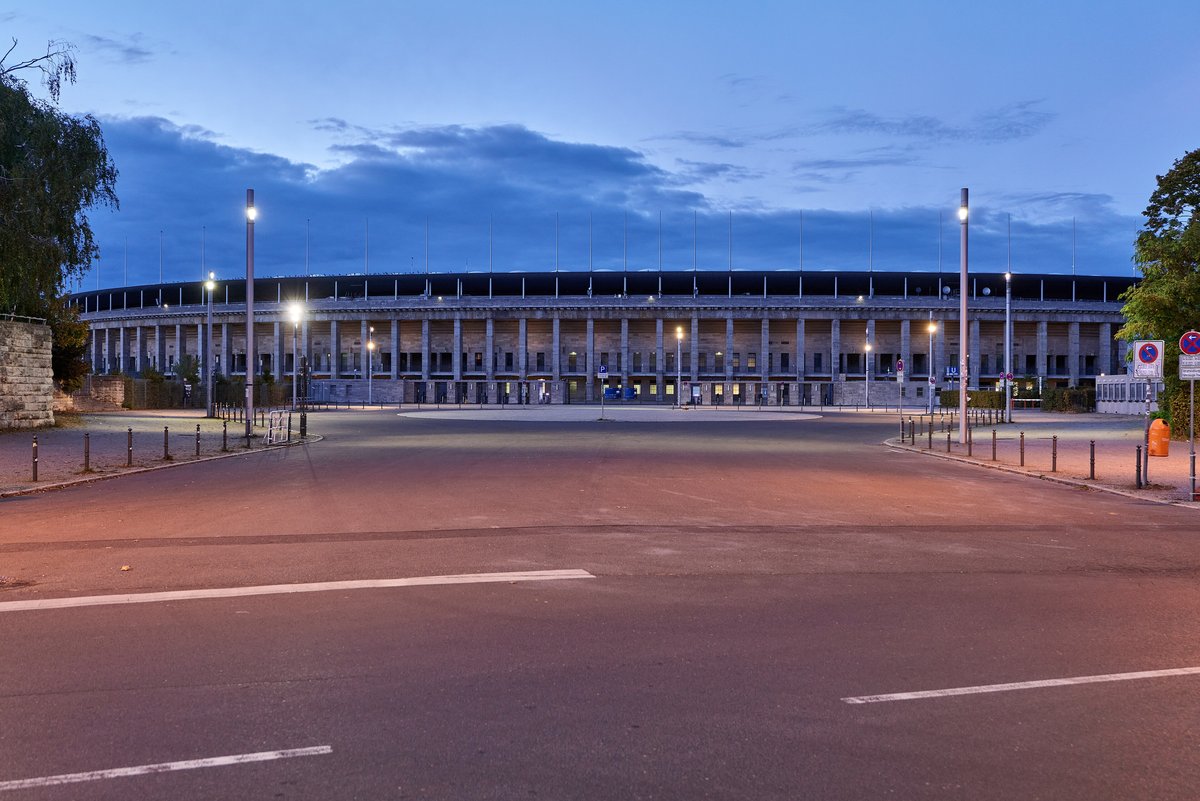 Façade monumentale du stade olympique de Berlin au crépuscule, avec ses piliers de pierre
