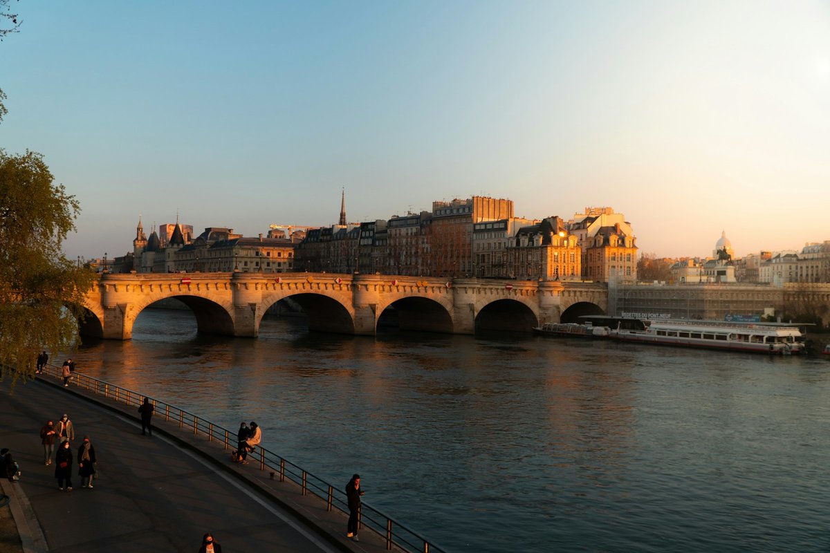 Quai de Seine au coucher du soleil, avec le Pont Neuf et des promeneurs