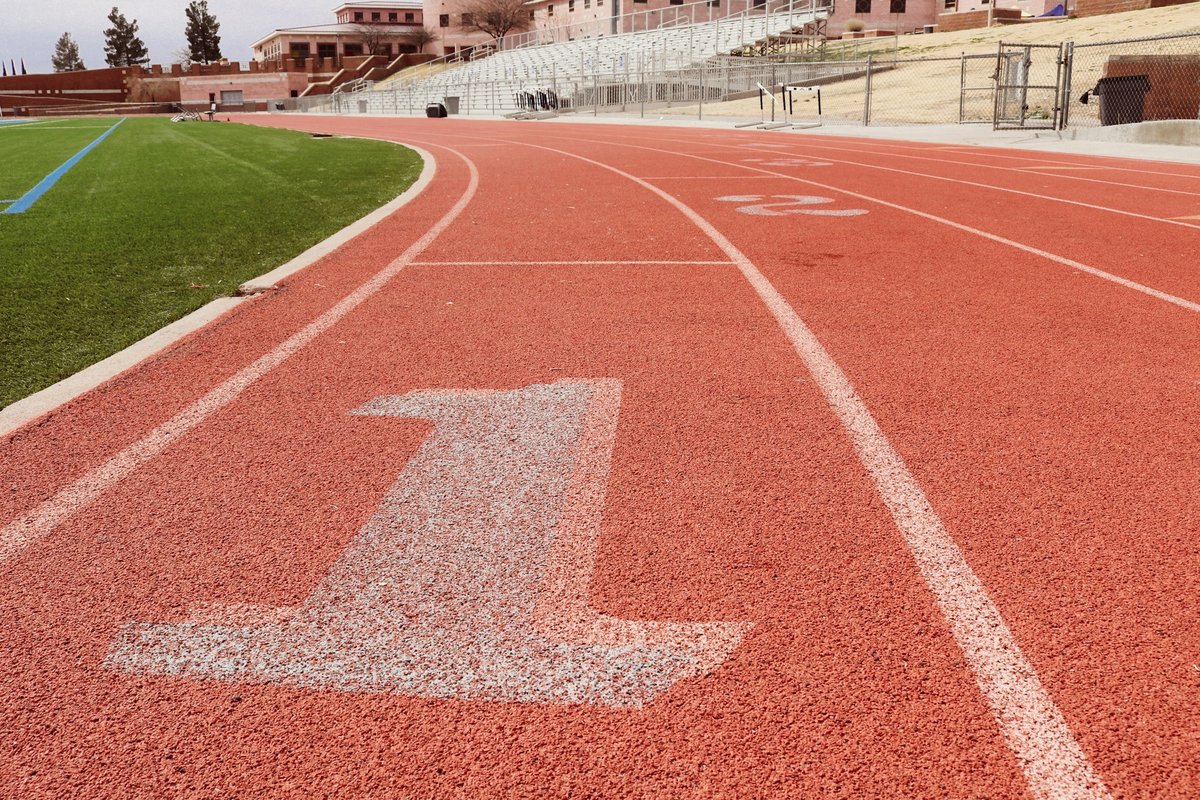 Couloir numéro un d'une piste d'athlétisme rouge, lignes blanches au sol